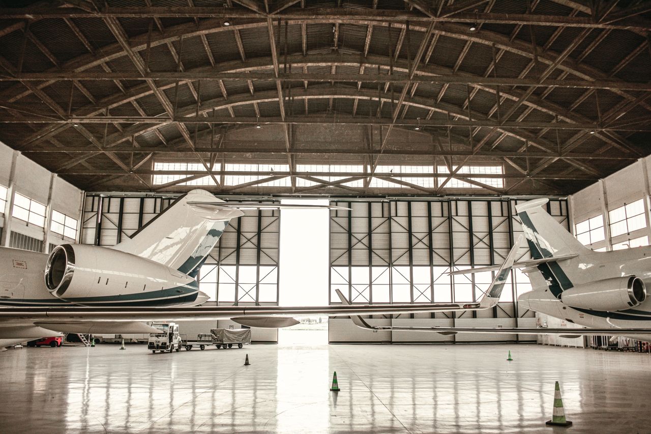 Private jets parked inside a large hangar in Paris, offering a glimpse into aviation luxury.