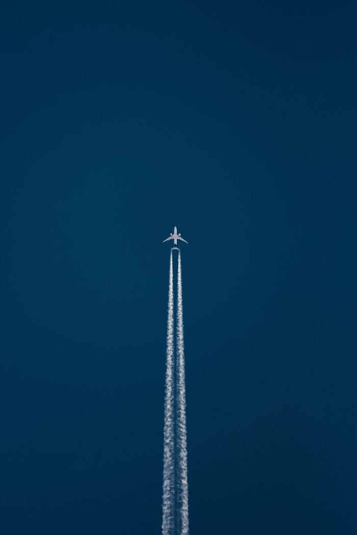 A jet airplane leaves a contrail across a clear blue sky captured in Jos, Nigeria.
