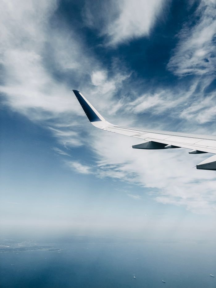 Mastering the First Impression: Your intriguing post title goes here A scenic view of an airplane wing cruising above the clouds, capturing the serene sky.
